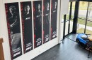 A banner, showing co-owners Michael Jordan and Denny Hamlin, as well as drivers Bubba Wallace, Corey Heim and Tyler Reddick, hangs in the lobby at Airspeed, the headquarters of 23XI Racing, Tuesday, Feb. 24, 2026 in Huntersville, N.C. (AP Photo/Jenna Fryer)
