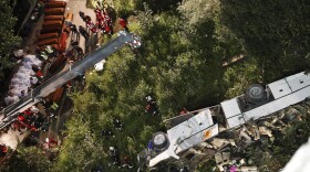 Rescuers prepare coffins for victims of a bus crash in southern Italy. At least 38 people died after a bus plunged off a highway and into a ravine.