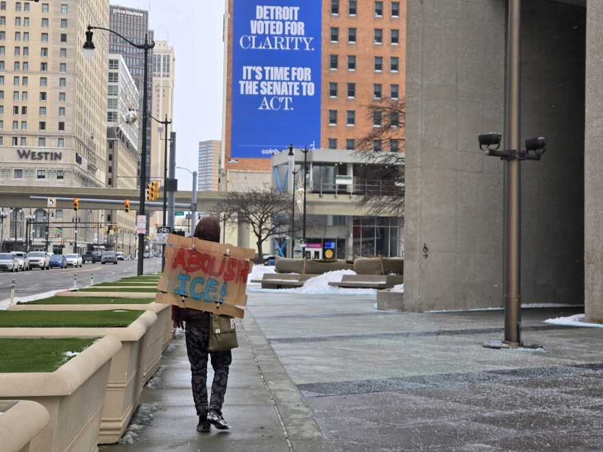 A demonstrator carries a sign reading "abolish ICE" in Detroit on Wednesday, January 28, 2026.