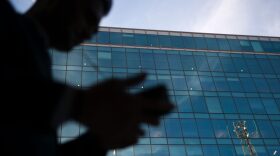 A businessman talks on his cell phone as he walks past an office on Oct. 11, 2016 in Washington, DC. (Andrew Caballero-Reynolds/Getty Images)