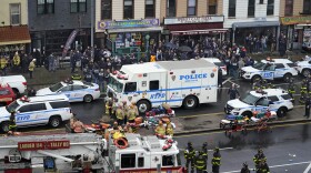 Emergency personnel gather at the entrance to a subway stop in the Brooklyn borough of New York, Tuesday, April 12, 2022. Multiple people were shot and injured Tuesday at a subway station in New York City during a morning rush hour attack that left wounded commuters bleeding on a train platform.