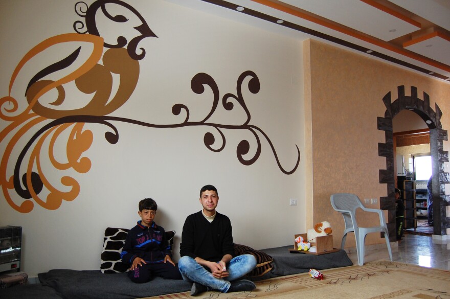 Hytham Harara, 21, sits with his little brother<em><strong> </strong></em>in their recently reconstructed home in Gaza City. The family returned home a couple months ago, after a year-and-a-half crammed into a rental.