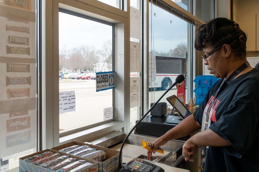 Nancy Sayles, 51, sells a bag of M&Ms to a commuter at the Belleville MetroLink station. She's one of six Challenge Unlimited clients working at the convenience store.