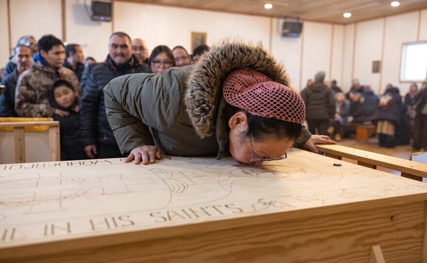 a woman kisses a coffin