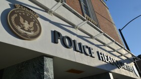 Closeup exterior of a brick building. A plaque on the outside shows an official seal with an eagle that reads "Police: Kansas City, Kansas." Large letters on the building read, "Police Headquarters."