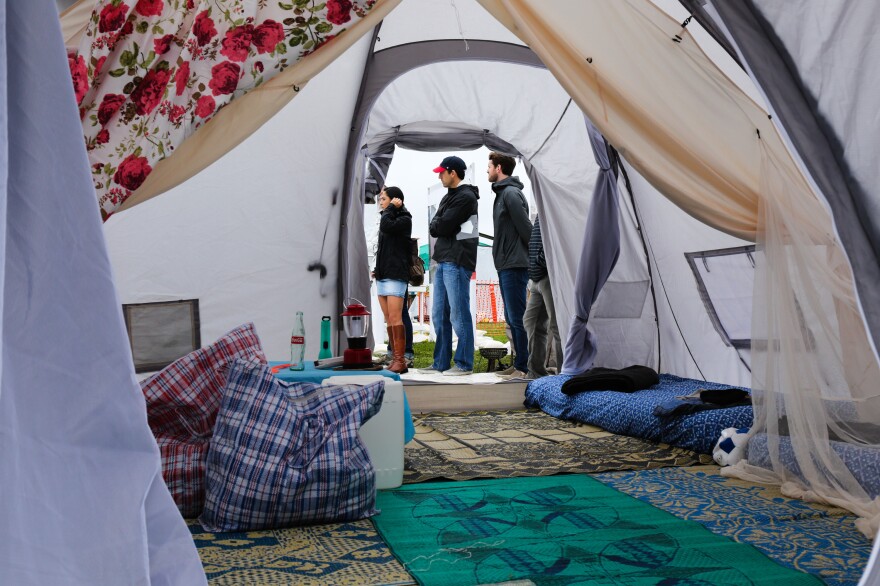 What it's like inside a two-family tent: A cloth divider to split the space in two, canvas mats, small mattresses.