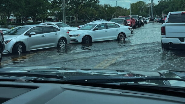 cars try to get through a flooded road