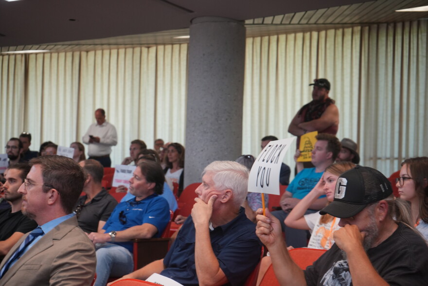 Knox County residents hold up signs opposing automatic license plate readers during a public workshop on August 24, 2026.