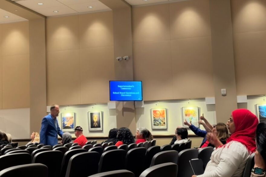 Clint McCracken, president of the Orange County Classroom Teachers Association, walks back to his seat after speaking during public comment at the Orange County Public Schools board meeting Tuesday. Members of the crowd raised their thumbs in approval as he returned to his chair.