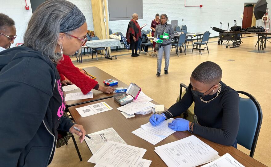 Toya Booker Thomas (L) fills out details about her quilts for the quilt documentation day as Liv Furman (R) takes down notes.