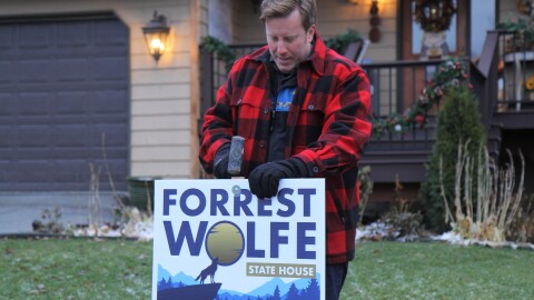 House District 21 candidate Forrest Wolfe puts up a yard sign in East Anchorage on Oct. 25, 2022. (Katie Anastas/Alaska Public Media)