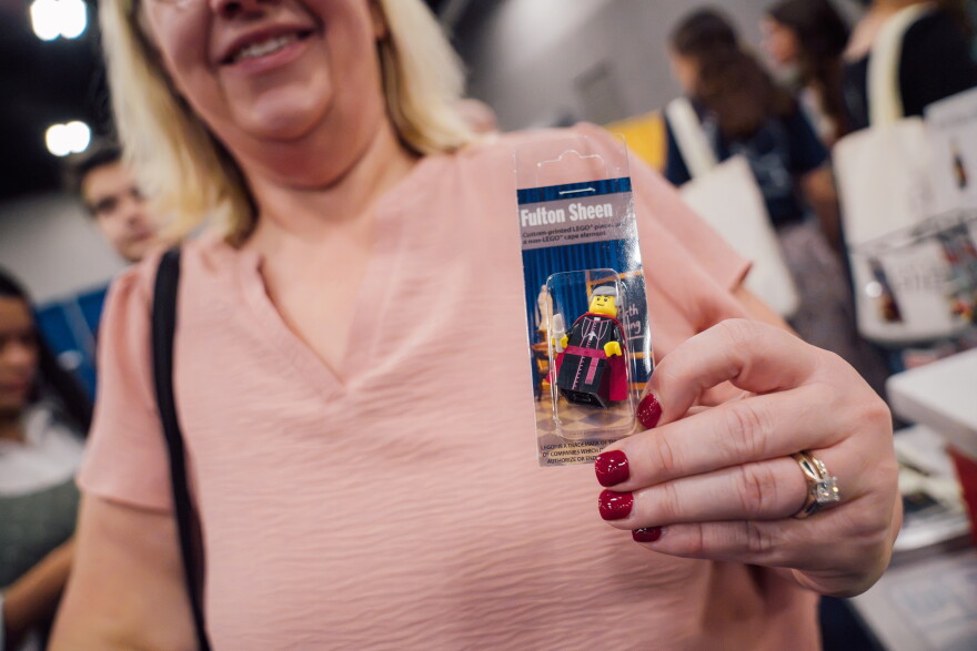 Carissa Hess, of Edwardsville, shows of a LEGO minifig depicting the late Archbishop Fulton Sheen ahead of the beatification Mass for the late Archbishop Fulton J. Sheen on Thursday at The Dome at America's Center.