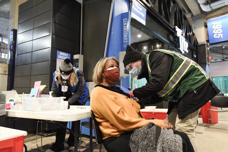 A patient is vaccinated at a mass COVID-19 vaccine clinic at Bank of America Stadium.