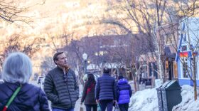 People walking around a snowy downtown area.