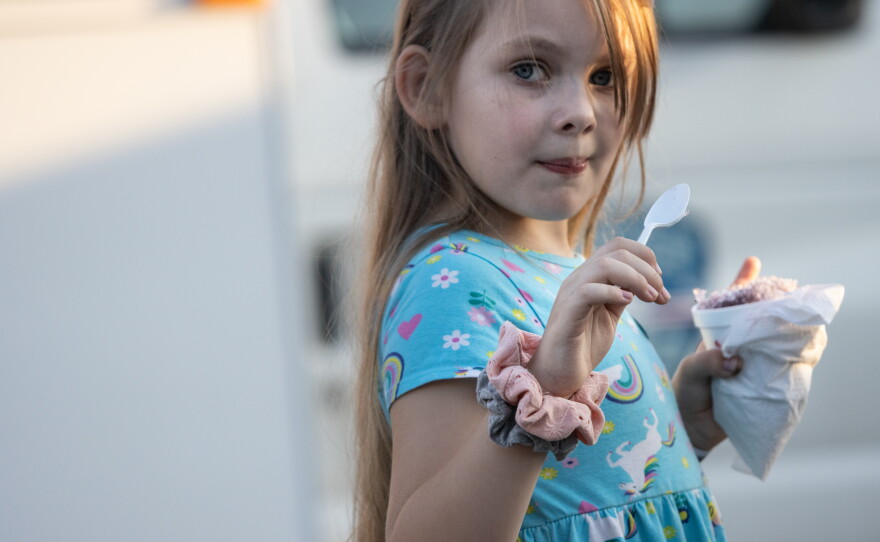 Lilliana Harpe, 5, eats a snow cone while attending National Night Out with her parents.