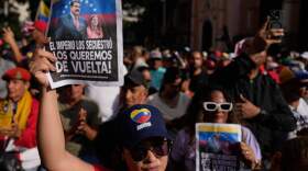 Government supporters hold posters that read in Spanish, "The empire kidnapped them; we want them back," during a protest demanding President Nicolas Maduro and first lady Cilia Flores release from U.S. custody in Caracas, Venezuela, Sunday, Jan. 4, 2026. (Ariana Cubillos/AP)