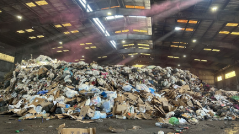 The “tipping floor,” where compactors shovel piles of trash before transport to the landfill. Hazardous waste is housed in a separate facility. (Natalie Kaufman/WUFT News)