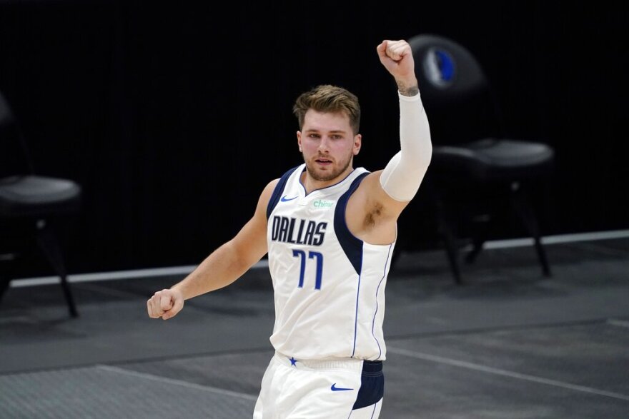 Luka Doncic raises his fist in celebration after making a basket against the Minnesota Timberwolves in a preseason game.