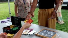 FILE - A woman exchanges EBT dollars for product vouchers at the West End Farmers' Market in Hartford on June 29, 2025. The market collaborates with End Hunger CT, which doubles up to $20 EBT dollars.