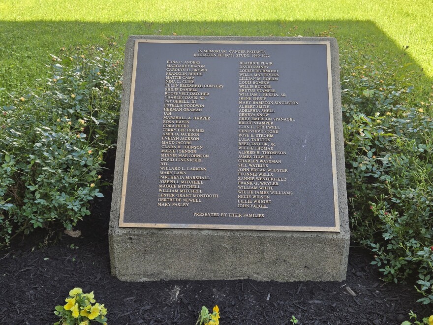 A plaque with a list of names in a field of grass