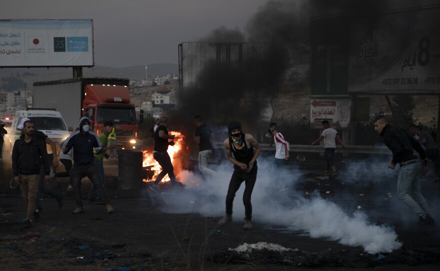 Palestinians clash with Israeli forces at the Hawara checkpoint, south of the West Bank city of Nablus on Sunday.