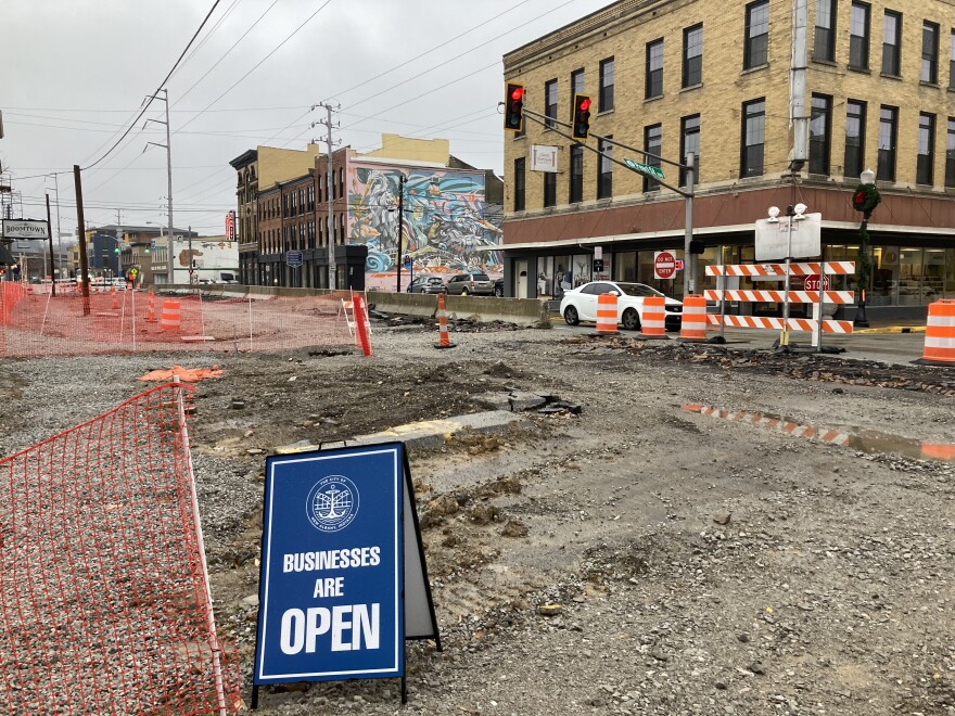 A sign advertising that "businesses are open" sits on gravel along Main Street in downtown New Albany, which has been under construction for months.