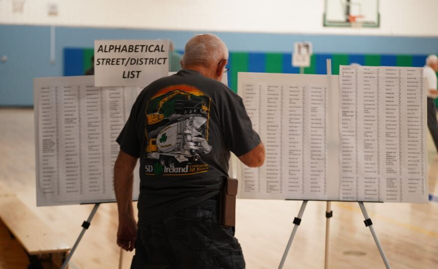 A person facing away from the camera looks at posters filled with text