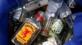 A volunteer displays nips she found in the bushes behind a park bench at Cleary Square in Hyde Park, MA on October 21, 2021. The group Keep Hyde Park Beautiful is making an effort to collect 10,000 discarded liquor nips bottles from the streets. With no deposits allowed on the tiny bottles, and no way to recycle them, the nips are a persistent litter problem.