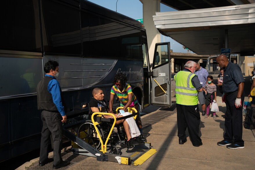 Hollins helps her son as he is lifted into the bus.