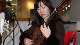 color photo of Xuefei Yang playing guitar in Classical 101 studio