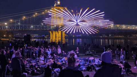 People watch a light show from below.
