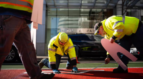 Workers place "Bus Only" signage on a new red transit lane in Portland, Ore., in this Oct. 30, 2019, file photo.