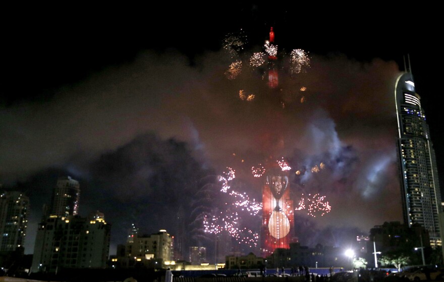 Smoke billows from the Address Downtown Hotel, at right, after it caught on fire hours earlier, as a fireworks display goes off near the Burj Khalifa in Dubai on Friday.