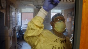 US Army Critical Care Nurse, Captain Edward Rauch Jr., writes on the door of a Covid-19 patient on a ventilator at Beaumont Hospital in Dearborn, Michigan on December, 17, 2021. Beaumont Hospital is assisted by 23 military medical personnel from the US Army, sent by the Department of Defense, to assist during the health system's fourth Covid-19 surge.