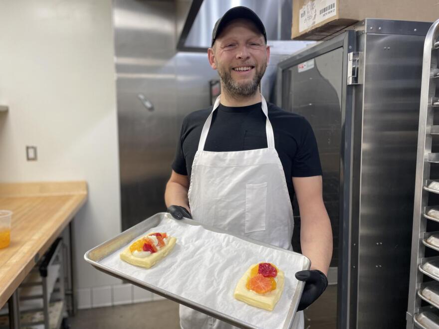 Man poses with tray of pastry