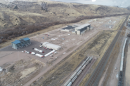 Aerial view of a partly-developed area near a railroad. It has a few large buildings scattered across but is otherwise empty.