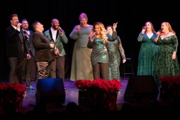 The voctave singers on stage in a semi-circle singing