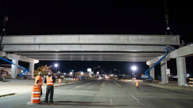 Crews watch the placement of concrete girders for the North South Corridor over Sprague Avenue.