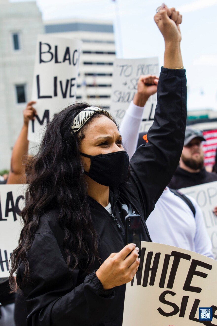 A woman holding a sign at a protest against police brutality.