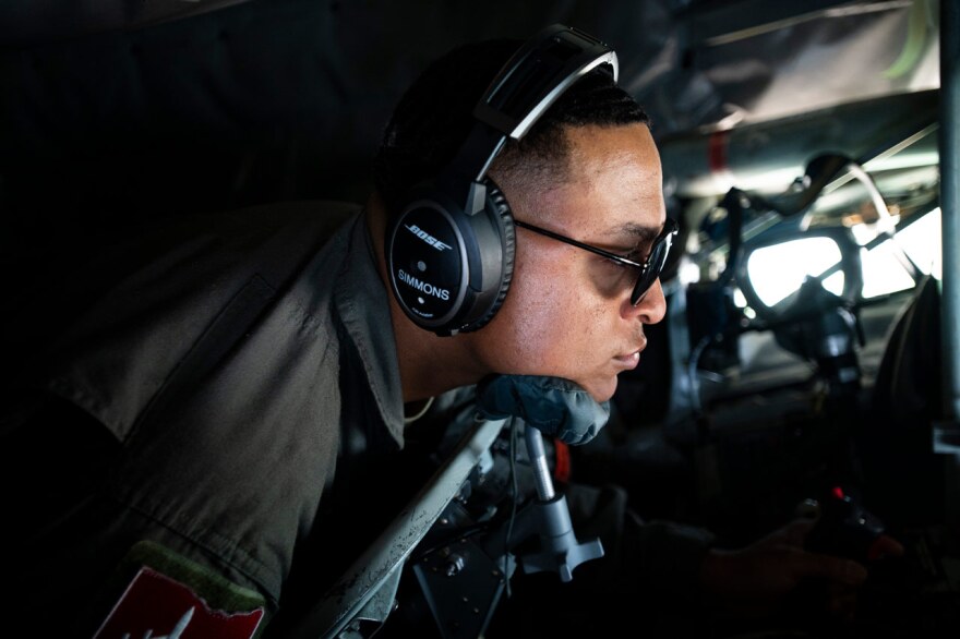 U.S. Air Force Tech. Sgt. Tyler Simmons in an airplane with headset and sunglasses on.