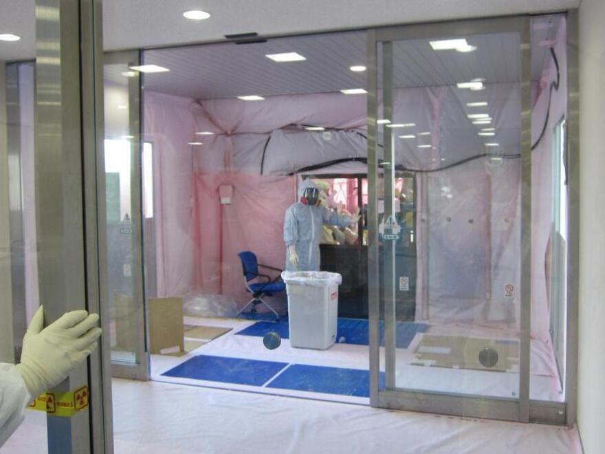 A radiation decontamination area was built into the entrance of a building at the Fukushima Dai-ichi power plant. Damage to the facilities and the reactor buildings is slowing efforts to stabilize the nuclear crisis.