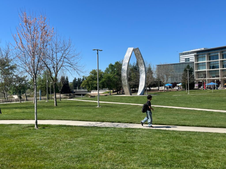 A student walks in front of the "Beginnings Sculpture" on the UC Merced campus on Thursday, March 26, 2026.