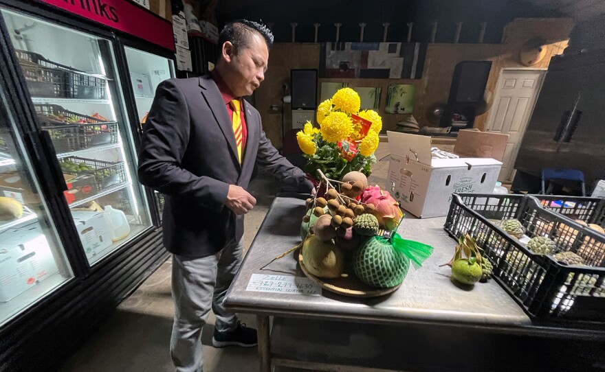 Tam Le rearranges fruits from Five Sisters Fruit Farms in Homstead onto a plate.