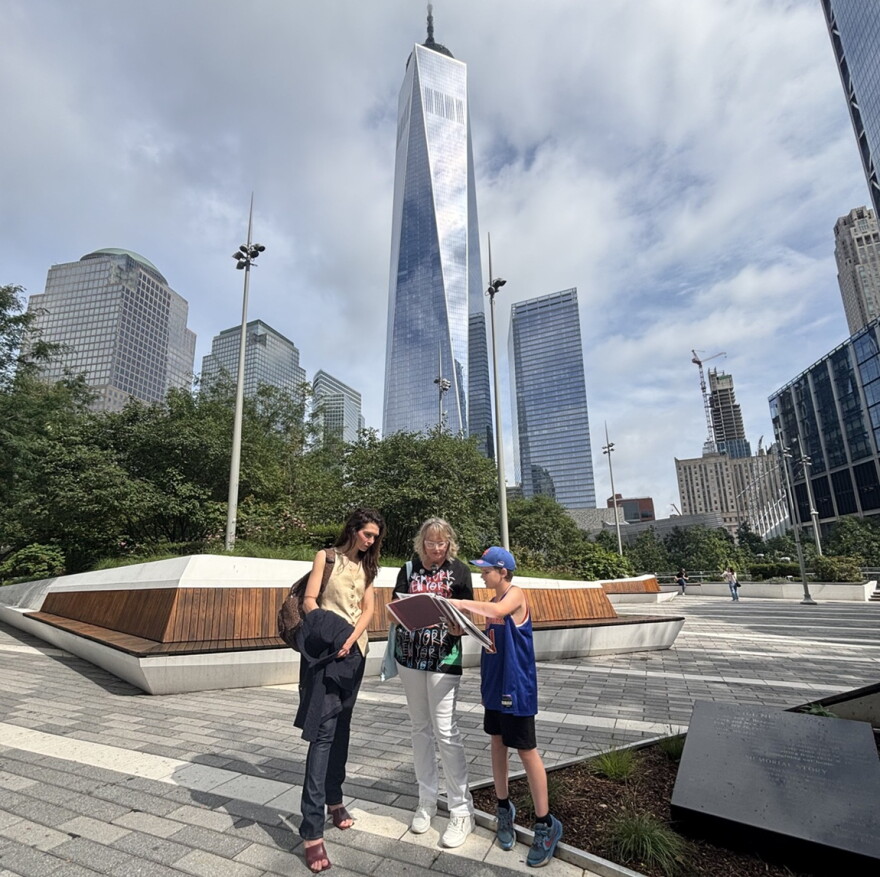 Christina Stanton talks to tourists with NYC's Freedom Tower in the background