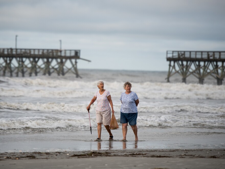 NORTH MYRTLE BEACH, SC - AUGUST 4: Mary McCants, left, and Amy Garrett walk near a damaged pier after Hurricane Isaias came through the night before on August 4, 2020 in North Myrtle Beach, South Carolina. Hurricane Isaias was downgraded to a tropical storm on Tuesday after making landfall overnight as a Category 1 hurricane. (Photo by Sean Rayford/Getty Images)