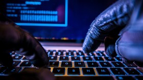 Hacker in black gloves hacking the system.