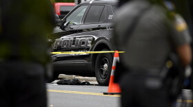 Investigators work the area near the vehicles of Bristol Police Officers killed near 310 Redstone Hill Road In Bristol, Connecticut October 13, 2022.