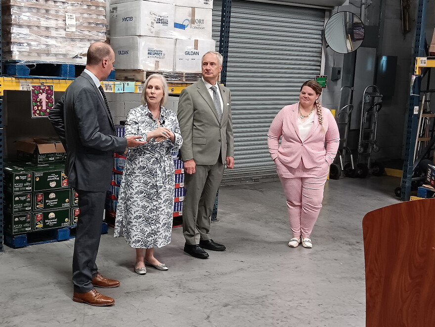 Senator Kirsten Gillibrand (second from left) speaks with Collin Bishop, vice president at FeedMore WNY, while Buffalo mayor Sean Ryan and FeedMore WNY's Kala Hagen listen, Friday, August 28, 2026.