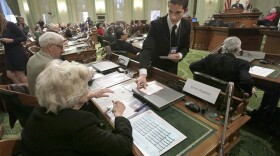 Electoral College member Christopher Tumbeiro, right, passes a ballot to Gwen Regalia, before the votes were taken for president and vice president, at the Capitol in Sacramento, Calif., Monday, Dec. 17, 2012. (Rich Pedroncelli/AP)