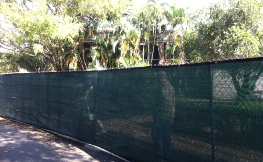 Workers behind the fence are cutting the concrete.